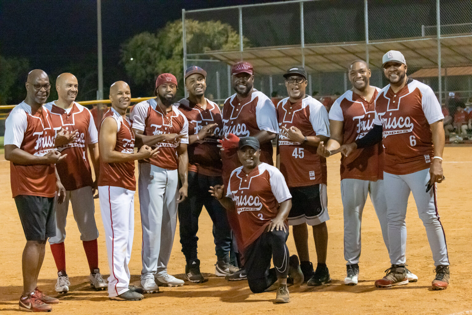 A group of men standing on top of a baseball field.