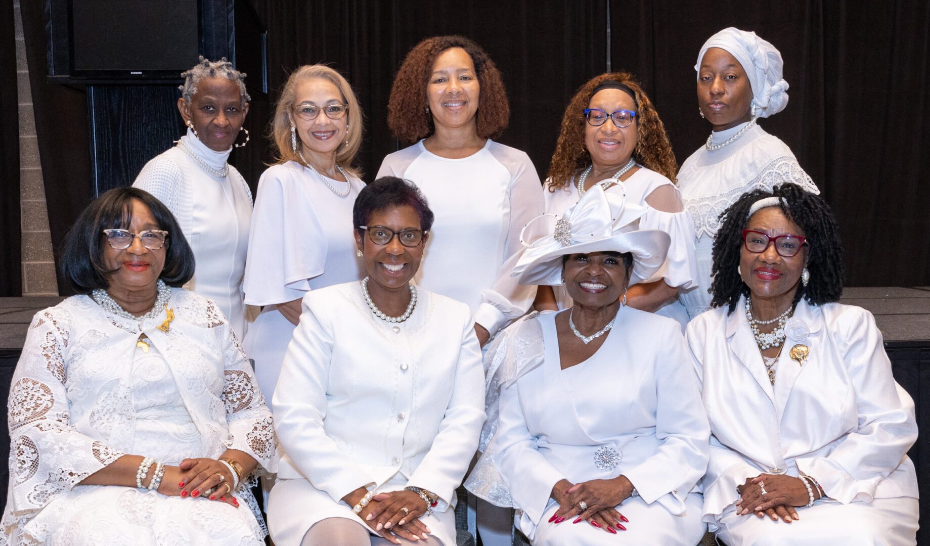 A group of women in white dresses and hats.