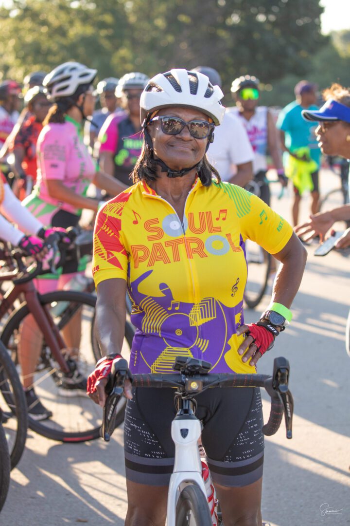 A woman in yellow shirt riding bike on street.